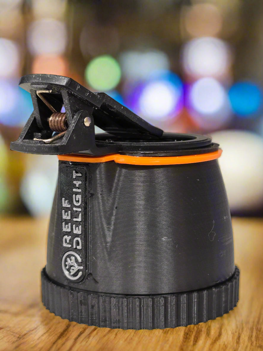 Close-up of a black and orange light fixture with 'Delight' branding on a blurred background